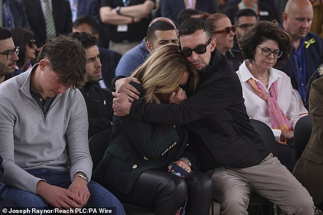 Lee Coates, Ian Coates' son, hugs Barnaby's mother Emma during Thursday's emotional vigil.