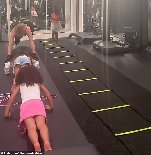 Then, when Khloé dropped to the floor to do a series of push-ups, the girls lined up nearby and touchingly attempted to do the same.