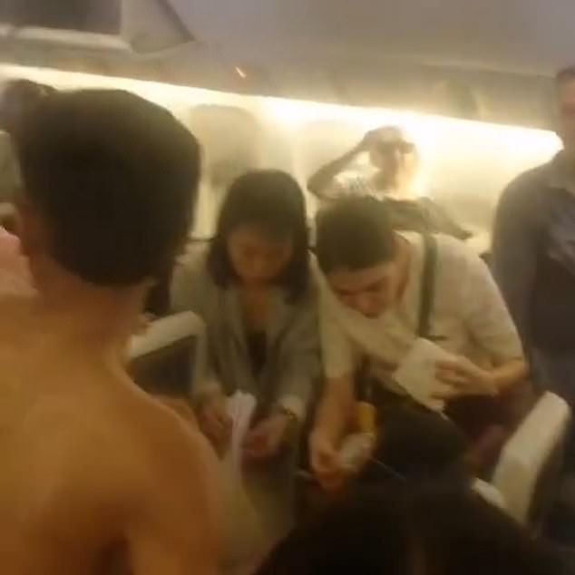 Passengers appeared to be using paper bags provided for motion sickness to fan the woman.