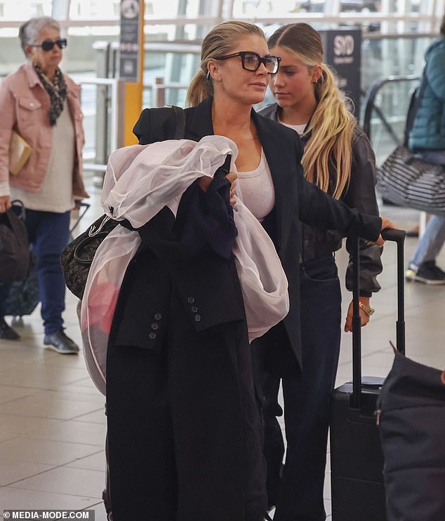 Natalie's brunette hair was pulled back into a ponytail and she appeared to be in good spirits as she chatted with her lookalike daughter as they made their way through the bustling airport.