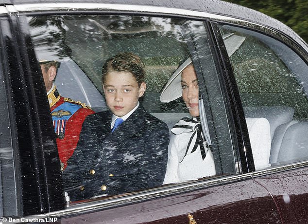 George sits between his mother Kate and father Prince William in the car in London today.