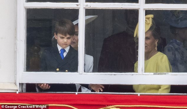 Prince Louis, known for his daring antics, tries to open a window during Trooping the Color today