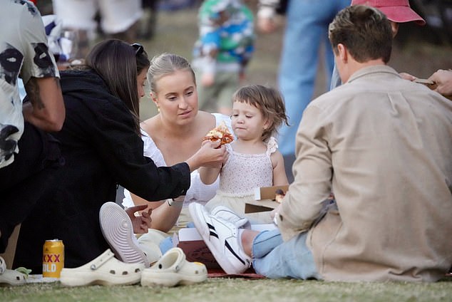 Matt and Annelyse brought a stack of pizzas to the seaside park, while their friends brought bags of food and drinks, and Annelyse fed Posy.