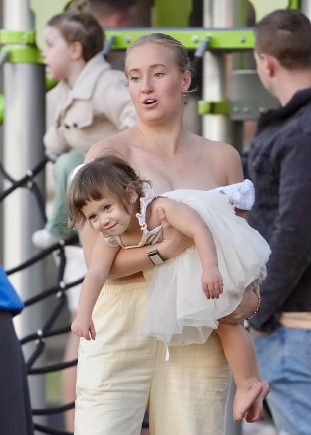 A family friend brought the child, who was wearing a sweet cream-colored dress.