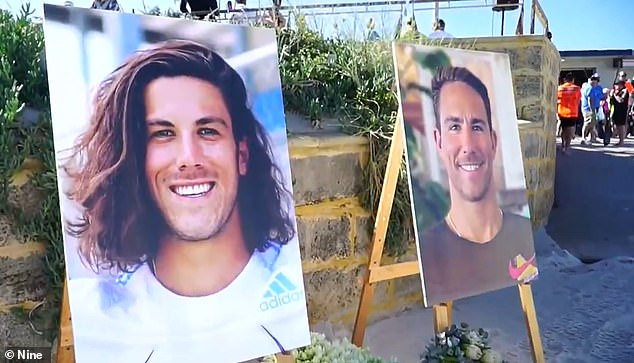 Two photographs of the brothers - Callum on the left and Jake on the right - were in the sand as hundreds gathered on the beach.