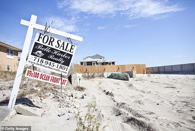 A for sale sign is posted on a beachfront property where a home used to stand before it was devastated by Hurricane Sandy in October 2013.