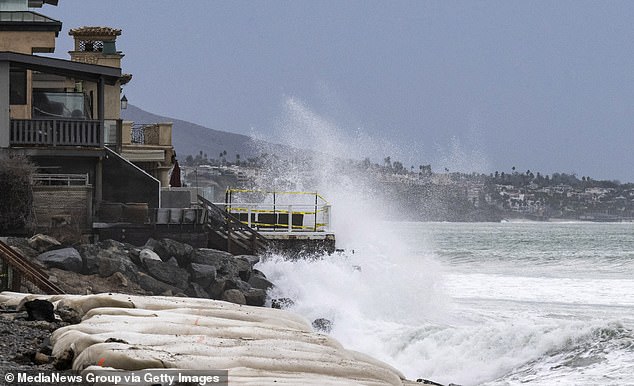 Waves crash against rocks in front of homes on Capistrano Beach in Dana Point, one of the most expensive real estate properties, and the hardest hit areas