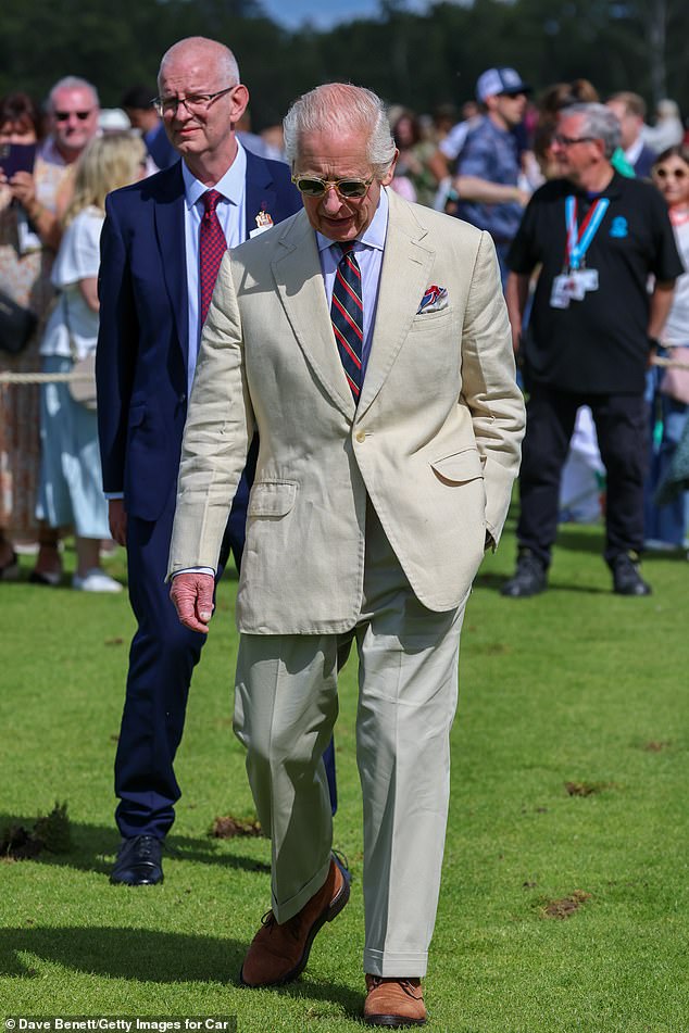 Charles wore his favorite Moscot sunglasses along with a light beige suit, a stylish navy, red and gold striped tie and brown suede shoes.