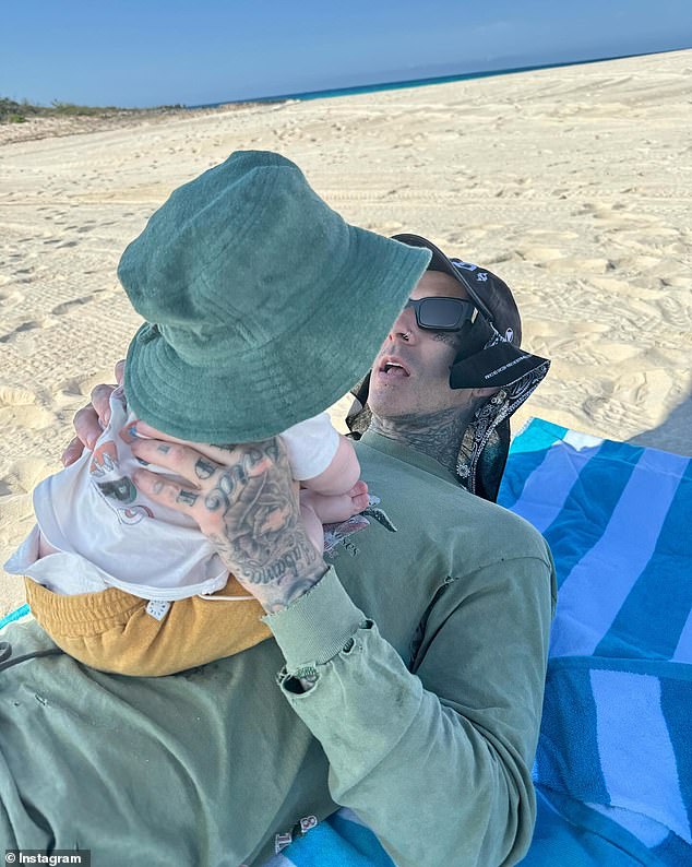 Included in the mother-of-four's photo roundup was an image of the Blink 182 drummer lying on a striped towel while holding her son to her chest.