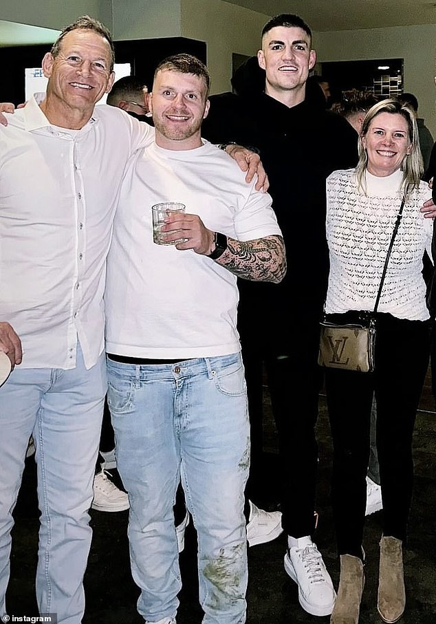 The field invader, second from left, posed for a photo with Maynard after the Marvel Stadium game who still had stains on the leg of his jeans.