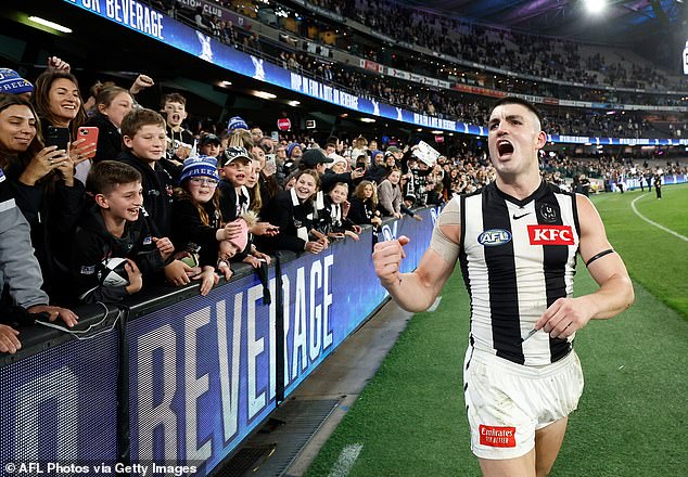 The Collingwood star celebrates with fans after the tense victory against the Kangaroos.