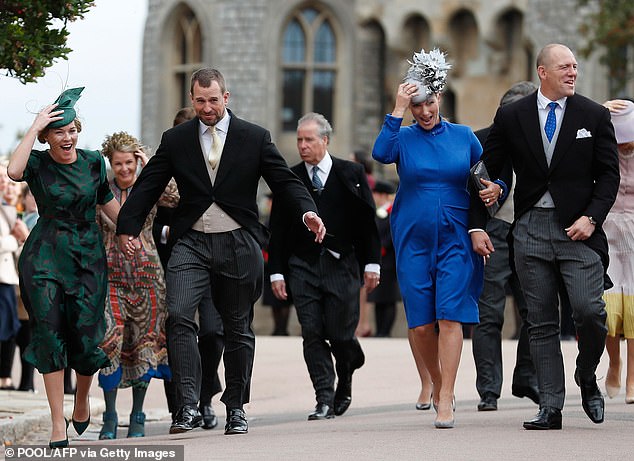 Peter Phillips (2L), Autumn Phillips (L), Zara Tindall (2R) and Mike Tindall (R) also fight the breeze at the wedding of Princess Eugenie and Jack Brooksbank.