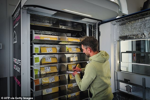 Vending machines are appearing in railway stations, town squares and motorway services (Pictured: Fabian Picard, director of the La fromager dairy, fills his vending machine with cheese in Bourg en Bresse, eastern France)