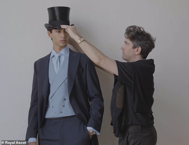 Fletcher is pictured altering a hat on a model's head for her lookbook photo shoot.