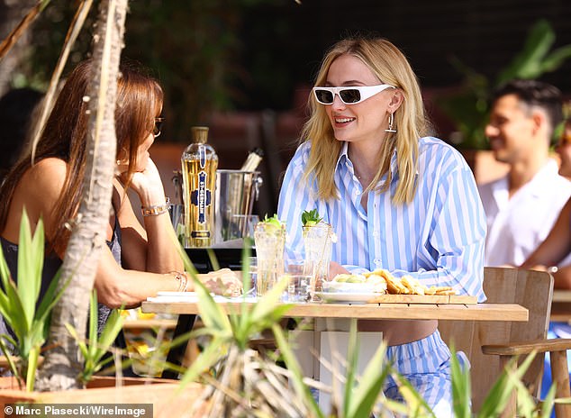 She showed off her cinched waist in low-rise pants and wore a matching long-sleeved cropped shirt.