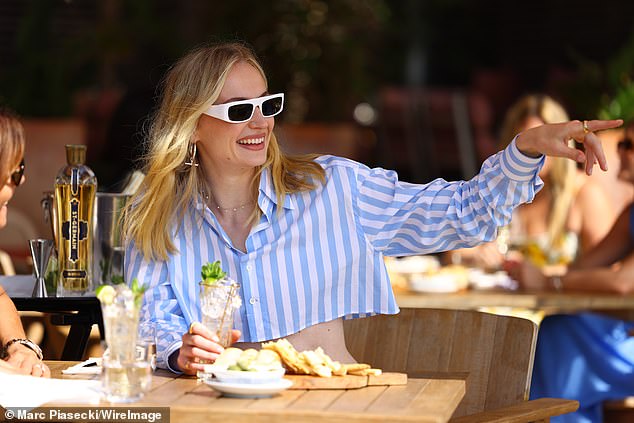 The blonde beauty paired her ensemble with trendy green sneakers and a cream-colored bag.