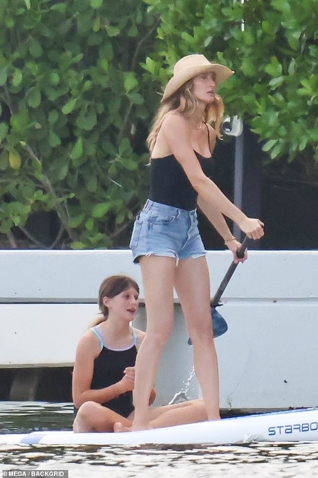 Gisele showed off her summery eye for style in a black scoop-neck tank top, denim shorts, and a wide-brimmed straw hat resting atop her golden locks.