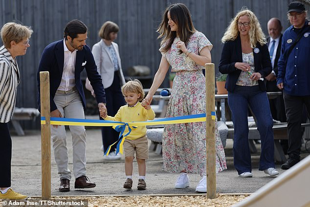 The family toured the grounds of the new playground and stopped to cut the colorful ribbon in the colors of the Swedish flag to mark the opening.