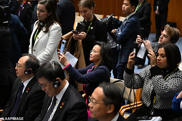 An Australian media official (pictured in cream jacket) came to Ms Lei's aid and 