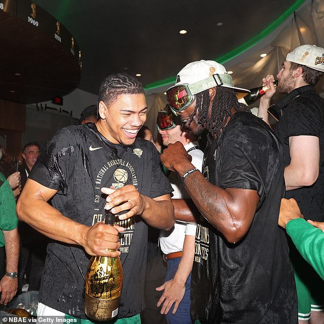 Jaden Springer and Jrue Holiday celebrate with a golden bottle in the Celtics locker room