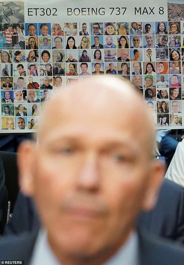 A poster with photographs of those killed on Ethiopian Airlines Flight 302 is held up as Boeing CEO Dave Calhoun testifies before the Senate.