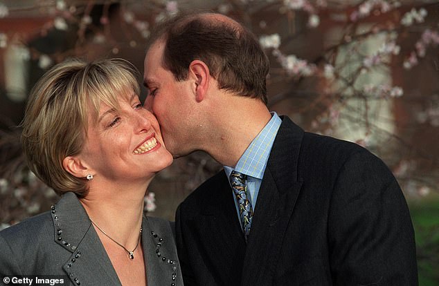 Sophie Rhys-Jones smiles widely as Prince Edward kisses her on the cheek during the announcement of their engagement in January 1999.