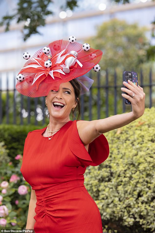 Lisa accessorized the eccentric hat with a red midi dress that had ruched details at the waist and looked in high spirits as she posed for selfies.