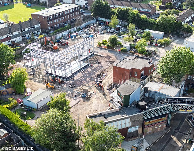 Aerial photographs show a huge metal structure under construction in the center of the land, with a new restaurant or pub with a green facade.