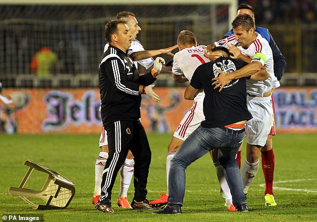 Albania striker Bekim Balaj is hit by a chair thrown by a Serbian fan as tensions boiled over during the Euro 2016 qualifying clash.