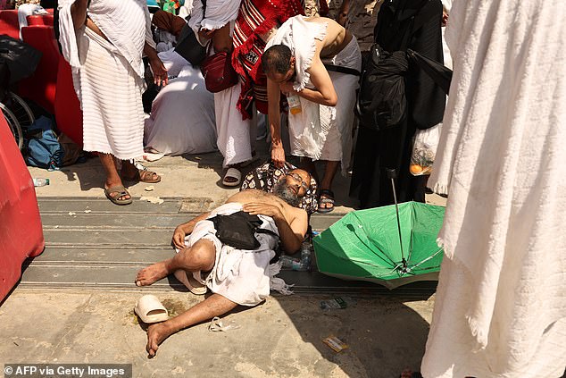 A man, apparently suffering from heat stroke, receives help from another Muslim pilgrim earlier this week.