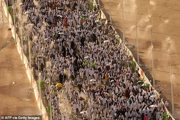 Muslim pilgrims walk under mist dispensers, which Saudi authorities have installed to try to keep people cool.