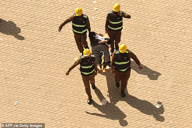 Lifeguards carry a man affected by the scorching heat on a stretcher