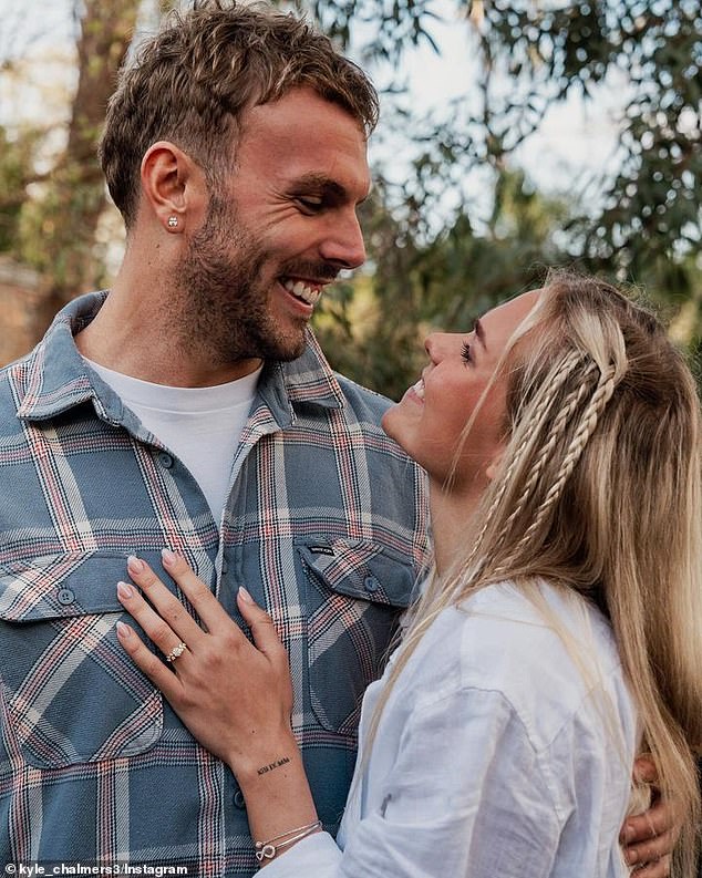 In the first image, Kyle is seen smiling as his Norwegian love tenderly rests her hand on his muscular chest, giving fans a glimpse of her stunning engagement ring.