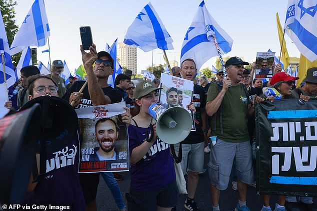 People hold up banners and portraits of Israelis held hostage by Palestinian militants in Gaza, during an anti-government demonstration in front of the Israeli Parliament in Jerusalem calling for early elections on June 17, 2024.