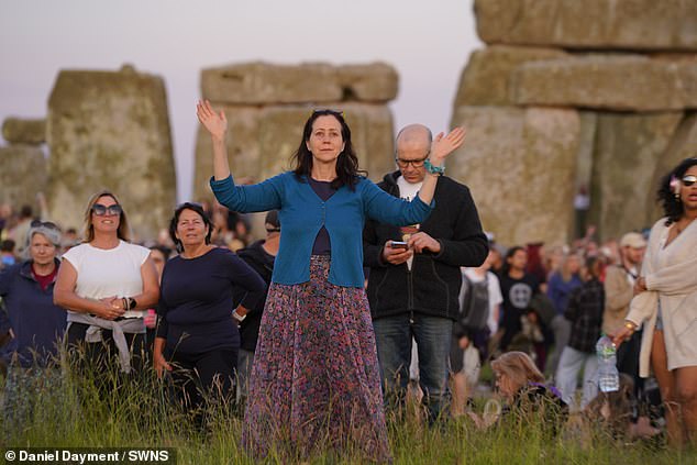 Revelers watch the sunset at Stonehenge on Thursday night