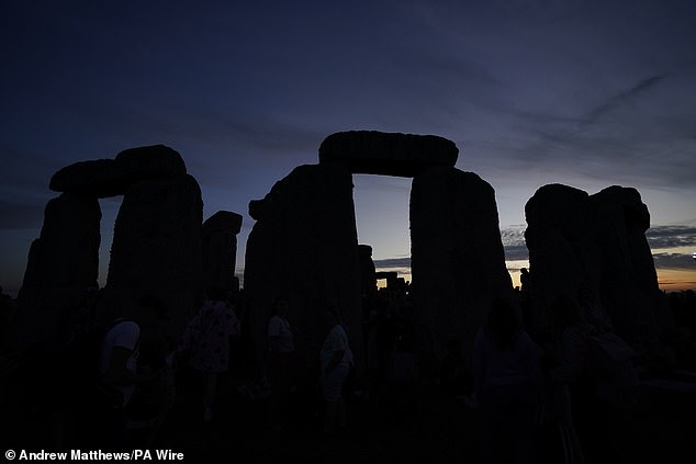 People gather during sunset at Stonehenge in Wiltshire