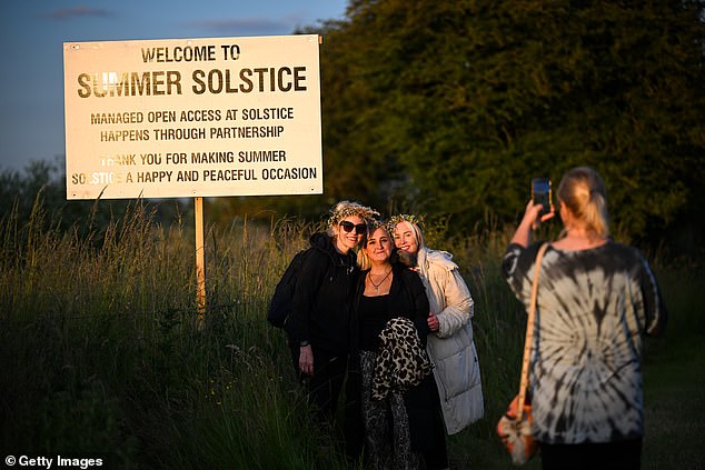 Visitors take a photo as they walk towards the stones of Stonehenge.