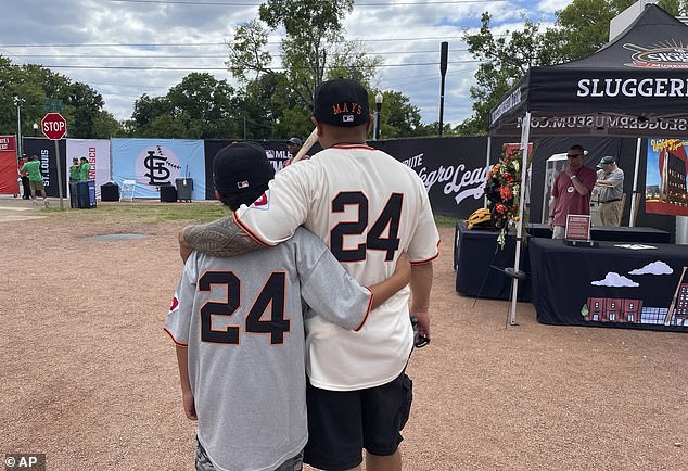 Eddie Torres, right, and his son Junior, from California and wearing San Francisco Giants uniforms with Willie Mays' number 24 on the back.