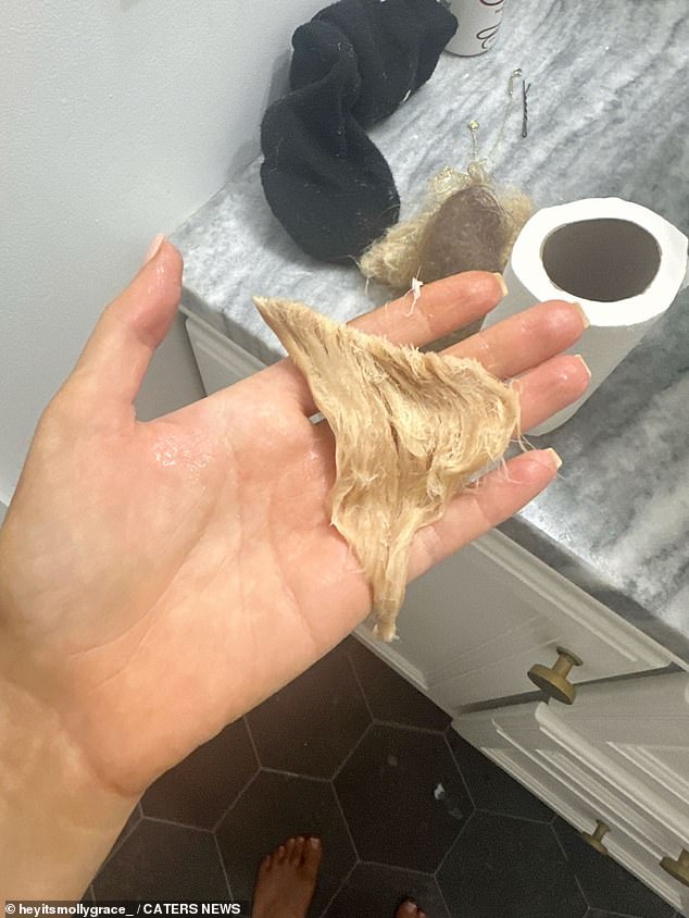 Molly holding a lock of her damaged, bleached blonde hair in her bathroom.