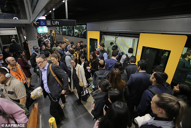 A record 547,300 migrants flooded into Australia in 2023, the highest number ever recorded in a calendar year (pictured, Sydney train commuters)