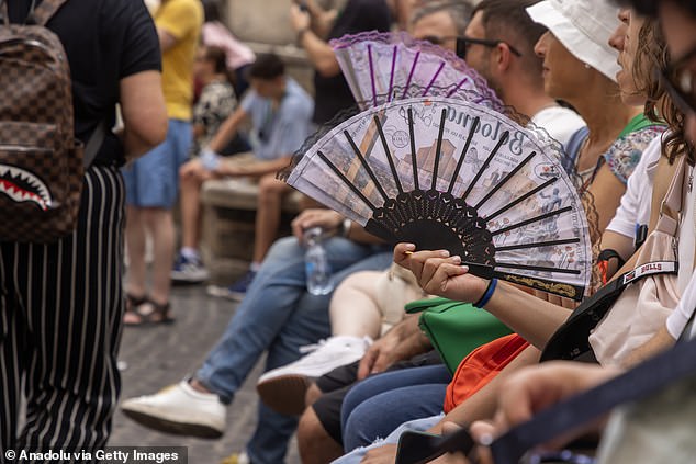 Tourists try to cope with the heat as the air temperature reaches 42 degrees Celsius on the streets of Rome.