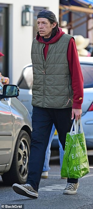 She added a khaki vest to the ensemble and completed the look with worn-out Converse.