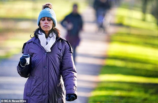 The Bureau of Meteorology says areas of low pressure that have been located along the Tasman Sea all week will continue to bring cold southerly winds along Australia's east coast on Saturday. A woman appears in the photo prepared for the cold.