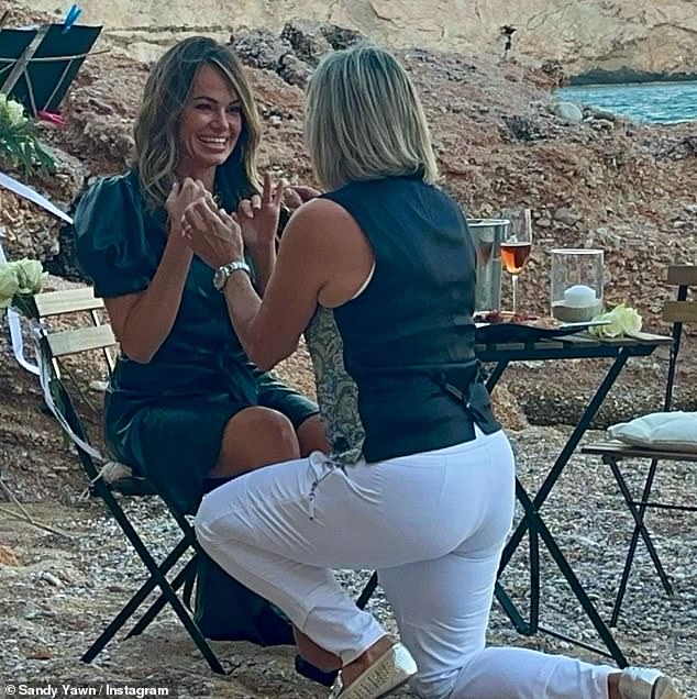 The couple had been dating for more than five years when Sandy popped the question during an intimate trip (the proposal is pictured) and they tied the knot less than a year later.