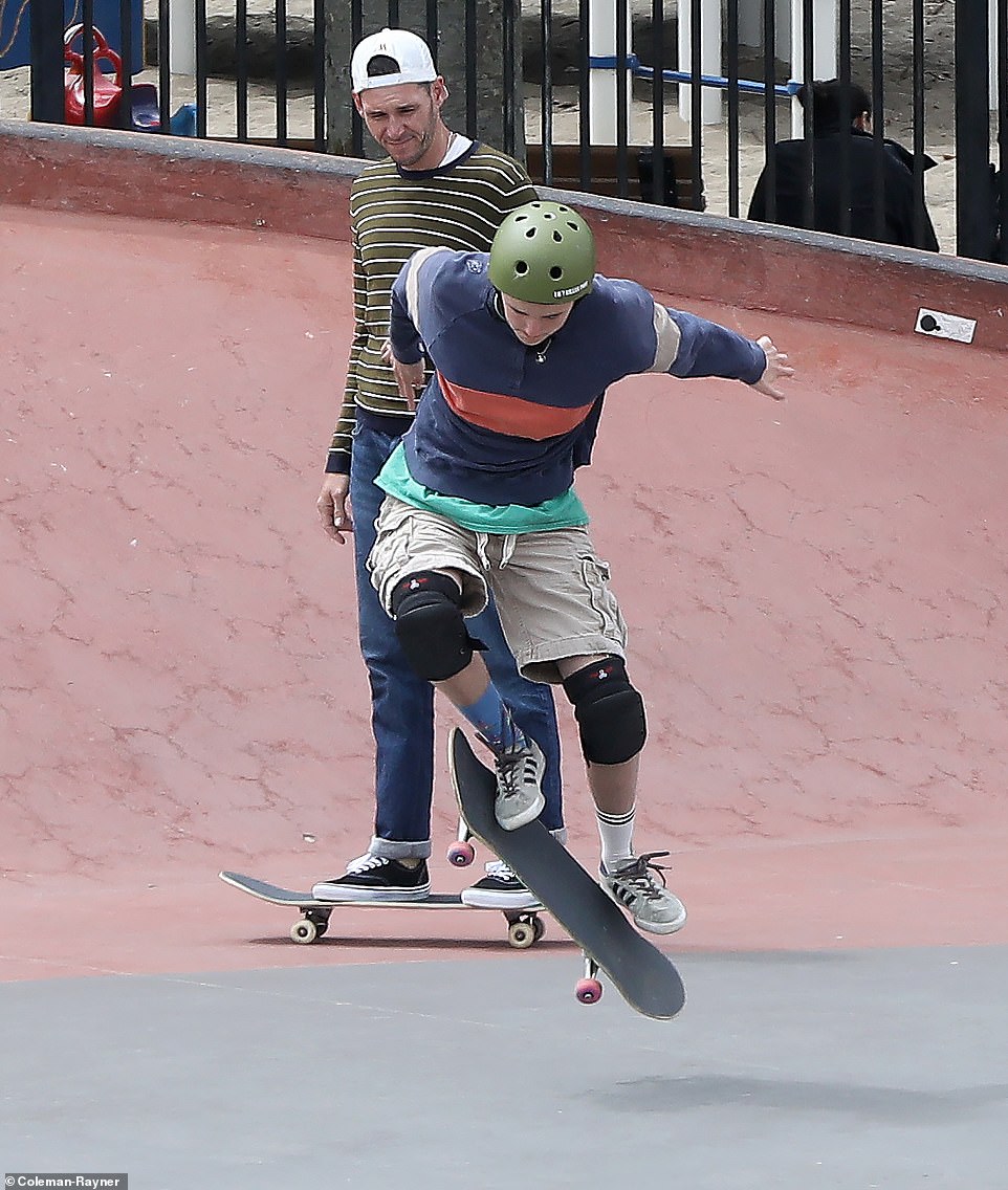 The teen wore tan shorts and a navy striped long sleeve with a green shirt underneath as he honed his skateboarding skills.