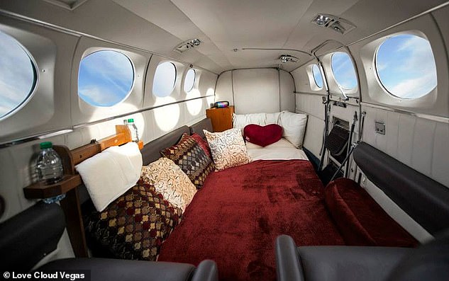 The interior of the Love Cloud plane (above) features a spacious bed, sheets, a blanket, cushions, and seats for takeoff and landing.