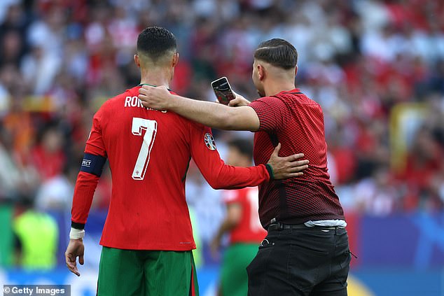 Another fan also tried to take a photo with Ronaldo, who seemed annoyed by the pitch invader.