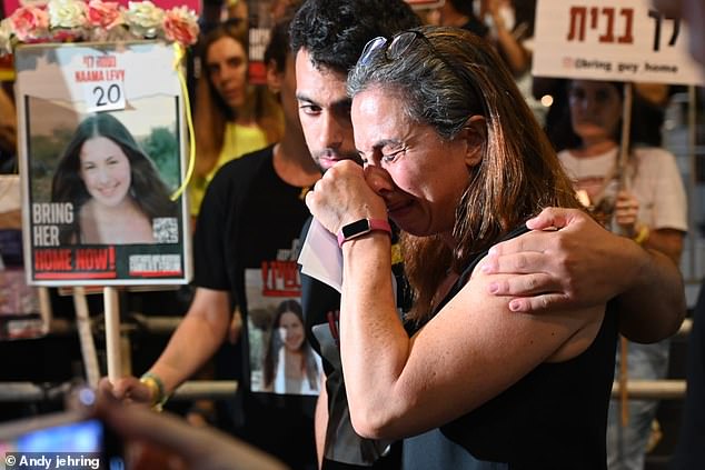 Ayelet Levy Shachar breaks down in tears and is comforted by her son, Amit, at the event.