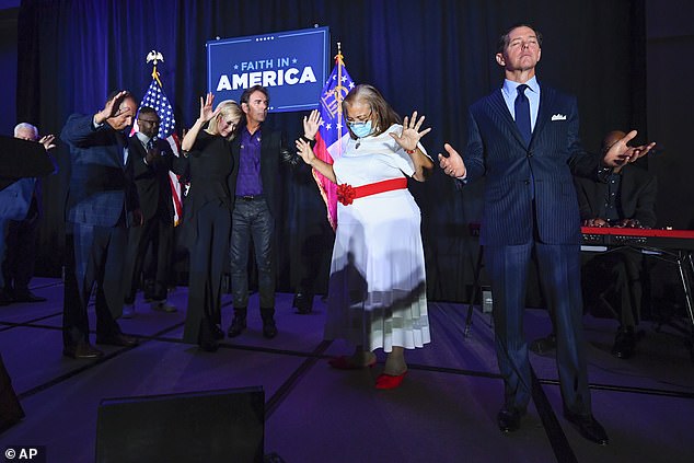 Ralph Reed, from right, Dr. Alveda King, Journey keyboardist Jonathan Cain and the president's personal pastor Paula White Cain, and others pray on stage during a Donald Trump campaign event.