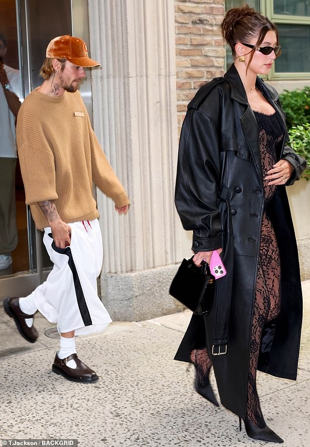 Balancing expertly on a pair of sky-high heels, the mother-to-be accentuated the look by wrapping herself in a long black leather coat.